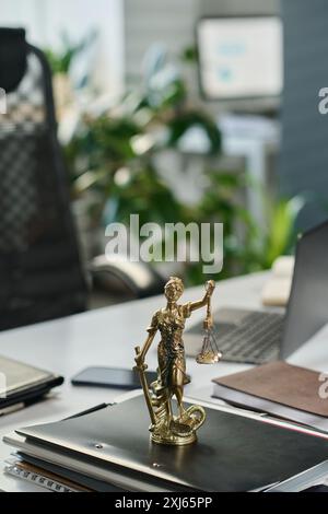 Statue en bronze de la déesse de la Justice Themis les yeux bandés avec échelle dans la main gauche et épée dans la droite debout sur le dessus de la pile de dossiers Banque D'Images