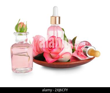 Assiette et bouteilles d'huile cosmétique avec extrait de rose sur fond blanc Banque D'Images