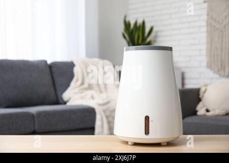 Humidificateur moderne sur la table basse près du canapé noir dans le salon, gros plan Banque D'Images