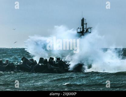 Vague de tempête s'écrasant contre le brise-lames et la tour à l'entrée du port, Klaipeda, Lituanie Banque D'Images