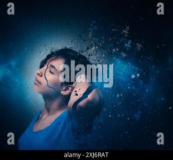 Portrait d'une jeune femme se brisant en mille particules entrant dans l'espace extra-atmosphérique Banque D'Images