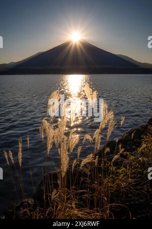 Sunburst sur le sommet du Mont Fuji avec le lac Yamanaka au premier plan, Fuji Five Lakes, préfecture de Yamanashi, Honshu, Japon Banque D'Images