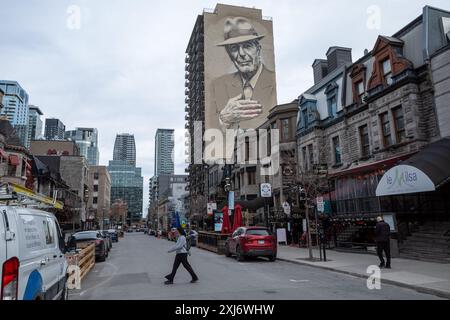 Au centre-ville de Montréal, au Canada, une magnifique murale orne la façade du bâtiment, inspirant et captivant les passants dans la rue animée ci-dessous. Banque D'Images