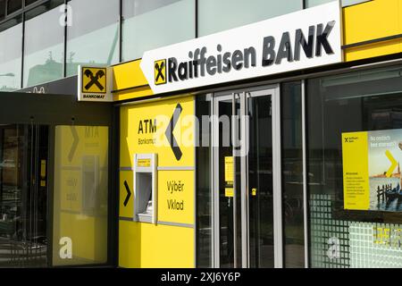 Prague, CZ -29.06.2024 : entrée de la succursale de Raiffeisen Bank à Prague avec un distributeur automatique de billets pour les transactions clients. Concept bancaire et financier. EDI Banque D'Images