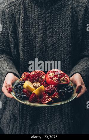 Femme tenant la plaque avec des fruits dans les mains Banque D'Images