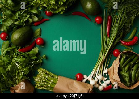 Vue de dessus du châssis ronds faits de divers légumes mûrs sur la surface verte Banque D'Images