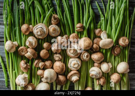 Vue de dessus de matières champignon champignons sur poireaux vert sur la table en bois Banque D'Images