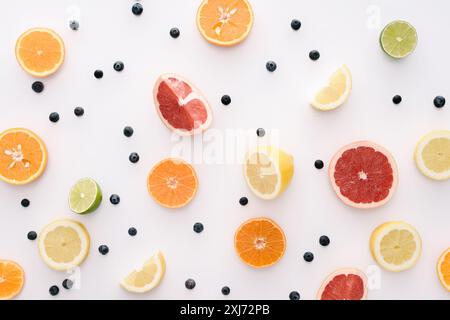 Vue de dessus les tranches d'agrumes et de bleuets sur surface blanche Banque D'Images