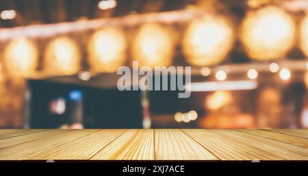 Dessus de table en bois vide avec café de restaurant ou intérieur de café avec lumière bokeh abstraite de style vintage flou pour fond d'affichage de produit de montage Banque D'Images