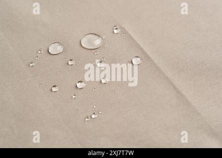Gros plan des gouttelettes d'eau sur la surface en tissu beige Banque D'Images