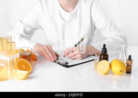 Produit d'aromathérapie. Scientifique développant des huiles essentielles à table blanche en laboratoire, gros plan Banque D'Images