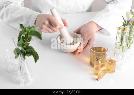 Produit d'aromathérapie. Scientifique développant des huiles essentielles à table blanche en laboratoire, gros plan Banque D'Images