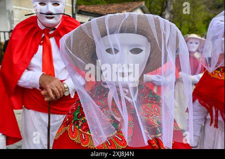 Les Madamitas de Entrimo, originaires de la petite ville d'Entrimo en Galice, font partie intégrante des célébrations Entroido (Carnaval) de la région. Originaires du XVIIIe siècle, ces figures représentent l’élégance et la grâce des femmes locales de cette époque. Vêtues de costumes élaborés et colorés ornés de dentelle, de rubans et de motifs floraux, les Madamitas symbolisent le patrimoine culturel et l’esprit festif d’Entrimo, donnant vie à l’histoire et à la tradition dans cette joyeuse célébration. Banque D'Images