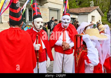 Les Madamitas de Entrimo, originaires de la petite ville d'Entrimo en Galice, font partie intégrante des célébrations Entroido (Carnaval) de la région. Originaires du XVIIIe siècle, ces figures représentent l’élégance et la grâce des femmes locales de cette époque. Vêtues de costumes élaborés et colorés ornés de dentelle, de rubans et de motifs floraux, les Madamitas symbolisent le patrimoine culturel et l’esprit festif d’Entrimo, donnant vie à l’histoire et à la tradition dans cette joyeuse célébration. Banque D'Images