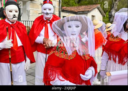 Les Madamitas de Entrimo, originaires de la petite ville d'Entrimo en Galice, font partie intégrante des célébrations Entroido (Carnaval) de la région. Originaires du XVIIIe siècle, ces figures représentent l’élégance et la grâce des femmes locales de cette époque. Vêtues de costumes élaborés et colorés ornés de dentelle, de rubans et de motifs floraux, les Madamitas symbolisent le patrimoine culturel et l’esprit festif d’Entrimo, donnant vie à l’histoire et à la tradition dans cette joyeuse célébration. Banque D'Images