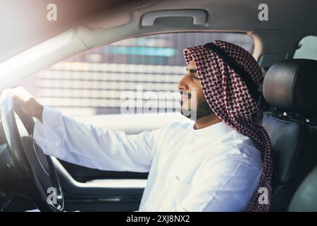 Homme arabe, voiture et conduite en ville pour le travail, les voyages et le transport pour les affaires ou le travail. Chauffeur, entrepreneur ou véhicule de luxe pour se rendre à Banque D'Images