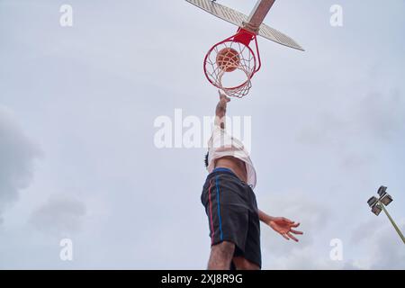 joueur de basket-ball faisant du slam dunk Banque D'Images