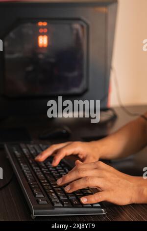 Un jeune adulte travaille depuis chez lui comme éditeur audiovisuel, créant du contenu et immergé dans un projet passionnant devant son ordinateur. Son espace refle Banque D'Images