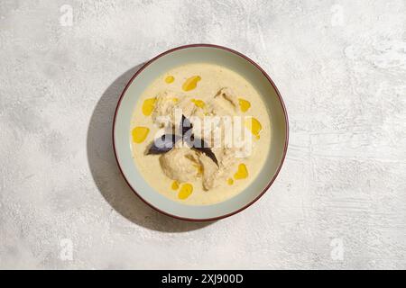 Vue aérienne de l'assiette avec des morceaux de poulet cuits dans la sauce aux noix Banque D'Images