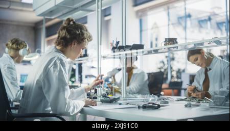 Équipe diversifiée de jeunes scientifiques multiethniques passant un stage dans un laboratoire de haute technologie moderne. Étudiants travaillant en laboratoire avancé avec des équipements scientifiques. Conception Microchip et développement électronique Banque D'Images