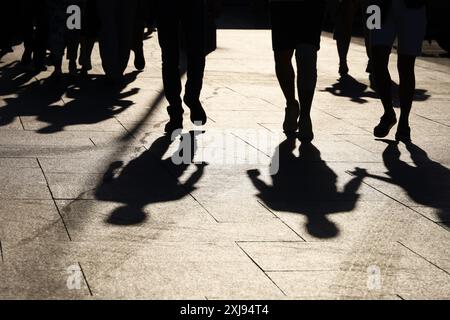 Silhouettes noires et des ombres de personnes dans la rue. Foule marchant sur le trottoir, concept de piétons, de la criminalité, de la société, de la vie en ville Banque D'Images