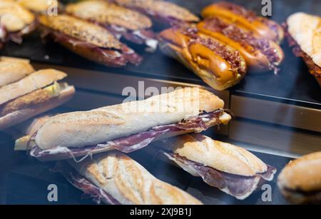 Sandwichs bocadillo de baguette avec jamon derrière le verre d'affichage Banque D'Images