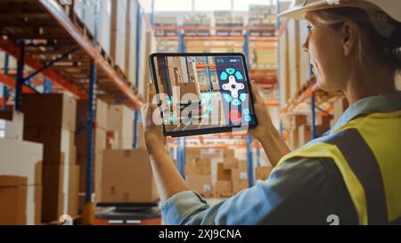 Concept de technologie future : femme ouvrière tenant tablette avec application de télécommande AR pour robot AGV d'entrepôt de détail avec infographie. Femmes contrôlant les véhicules guidés automatisés avec des produits. Banque D'Images