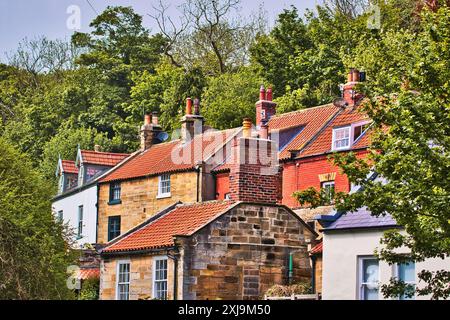 Une vue pittoresque de maisons traditionnelles aux toits de tuiles rouges nichées parmi les arbres sur une colline, Royaume-Uni, Europe Copyright : VasilexJechiu 1385- Banque D'Images