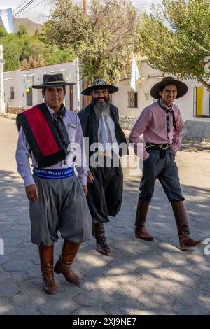 Trois gauchos dans leurs tenues traditionnelles, dont un avec le poncho rouge Salteño, à Cachi, en Argentine. Banque D'Images