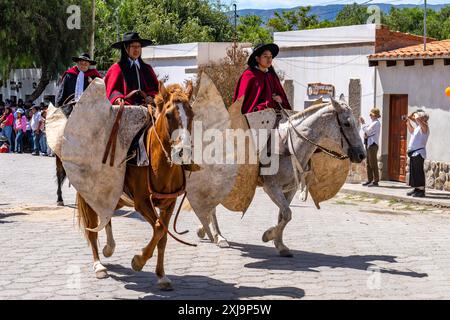 Deux gauchos féminines en robe traditionnelle dans une parade à Cachi, Argentine portant le poncho rouge Salteño. Traditionnellement appelé une «chine», un indigène Banque D'Images