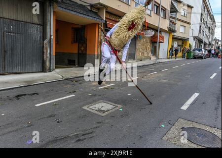 Un Sidro, un masque traditionnel de Valdesoto dans les Asturies, en Espagne, prend vie pendant le festival Mazcaraes d'Iviernu. Brandissant un long poteau, le Sidro utilise cet outil symbolique pour interagir avec la foule et chasser les mauvais esprits, incarnant le riche folklore et le patrimoine culturel au cœur des célébrations hivernales. Banque D'Images