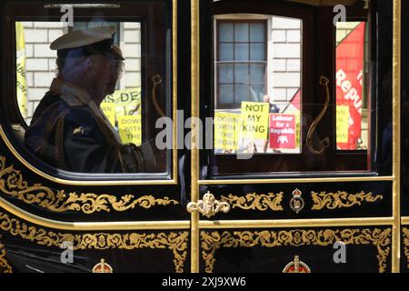 Les anti-royalistes bordent la route de Whitehall avec des banderoles et des pancartes disant «pas mon roi» et le travail pour Une république» alors que le roi Charles et la reine Camilla passent après avoir assisté à l'ouverture du Parlement. Londres, Royaume-Uni. 17 juillet 2024. Banque D'Images