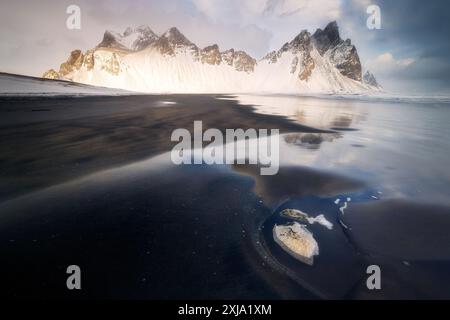 Vestrahorn majestueuse chaîne de montagnes en Islande avec des galets sur la plage de Stokksnes, plage volcanique de sable noir Banque D'Images