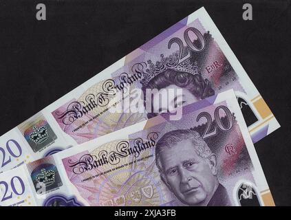 Gros plan de billets de 20 £ du Royaume-Uni avec un portrait du roi Charles III et de la reine Elizabeth II sur fond noir. Banque D'Images