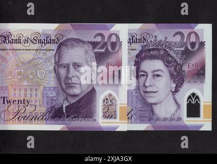 Gros plan de billets de 20 £ du Royaume-Uni avec un portrait du roi Charles III et de la reine Elizabeth II sur fond noir. Banque D'Images