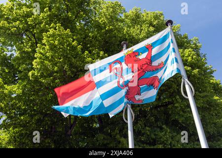 Europe, Luxembourg, Redange, les deux drapeaux nationaux du Luxembourg devant le cimetière de l'église de Victor Banque D'Images