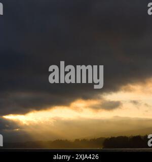 Soleil filtré à travers des nuages sombres, Puget Sound, WA, USA Banque D'Images