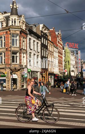 Un cycliste passe dans la rue de Muntplein, dans le centre d'Amsterdam, aux pays-Bas. Banque D'Images