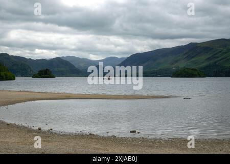 Une vue sur un lac avec quelques îles. L'arrière-plan présente une gamme de collines, probablement des montagnes, sous un ciel nuageux. Banque D'Images