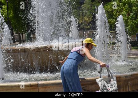 Une vague de chaleur prolongée approche du pic à Athènes Un touriste tente de se rafraîchir à une fontaine de la place Syntagma alors qu'une vague de chaleur prolongée approche du pic à Athènes. Athènes Grèce Copyright : xNicolasxKoutsokostasxNicolasxKoutsokostasx DSC 202407170124 Banque D'Images