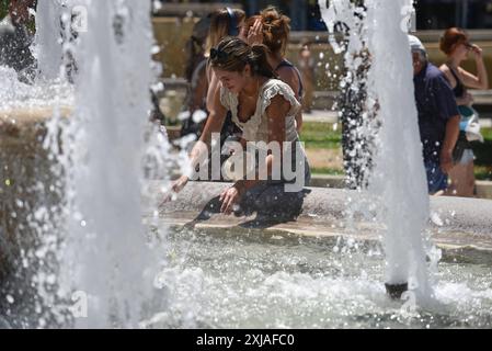 Une vague de chaleur prolongée approche du pic à Athènes Un touriste tente de se rafraîchir à une fontaine de la place Syntagma alors qu'une vague de chaleur prolongée approche du pic à Athènes. Athènes Grèce Copyright : xNicolasxKoutsokostasxNicolasxKoutsokostasx DSC 202407170302 Banque D'Images