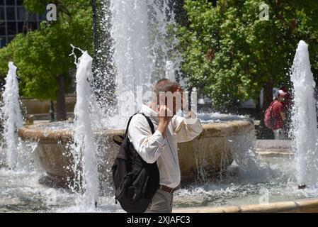 Une vague de chaleur prolongée approche du pic à Athènes Un homme tente de se rafraîchir à une fontaine de la place Syntagma alors qu'une vague de chaleur prolongée approche du pic à Athènes. Athènes Grèce Copyright : xNicolasxKoutsokostasxNicolasxKoutsokostasx DSC 202407170065 Banque D'Images