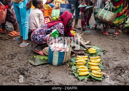 Un marché libre africain bourdonne d'activité un jour de pluie, car beaucoup de gens vendent et achètent des fruits, des légumes, des arts locaux, de l'artisanat et des outils Banque D'Images