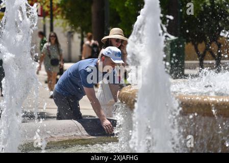 Une vague de chaleur prolongée approche du pic à Athènes Un touriste tente de se rafraîchir à une fontaine de la place Syntagma alors qu'une vague de chaleur prolongée approche du pic à Athènes. Athènes Grèce Copyright : xNicolasxKoutsokostasxNicolasxKoutsokostasx DSC 202407170249 Banque D'Images