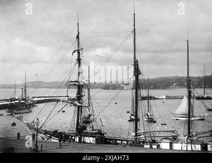 Une vue sur le port depuis Beacon Terrace, avec un bateau à trois mâts à quai. Torquay, Devon. Cette photographie est tirée d'un original édouardien, vers 1910. L'original faisait partie d'un album de 150 photographies d'albumen, de qualité variable, dont beaucoup j'ai photographié. La collection comprenait des images en particulier de l'île de Man et du comté anglais du Devonshire. Des annotations ont été incluses dans l'album mais, malheureusement, il n'y avait pas de dates précises. Les photos originales étaient en moyenne 6x4 ½ pouces. Banque D'Images