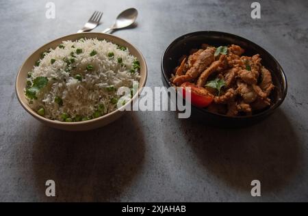 Riz indien et poulet servis dans des bols. Gros plan, mise au point sélective. Banque D'Images