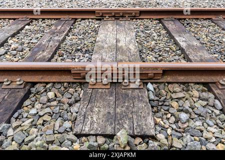 joint de rail à 4 boulons collé sur rails avec traverses en bois Banque D'Images