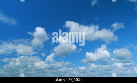 Time lapse. Formation de nuages traversant le ciel bleu. Nuages multicouches blancs et moelleux sur le ciel bleu. Banque D'Images