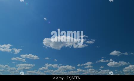 Time lapse. Des nuages blancs flottent à travers le ciel bleu. Des nuages doux et gonflés. Banque D'Images