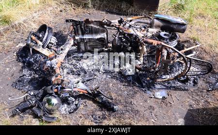 Moto brûlée couchée sur le sol avec des débris de cendres sombres à Manchester, Royaume-Uni Banque D'Images